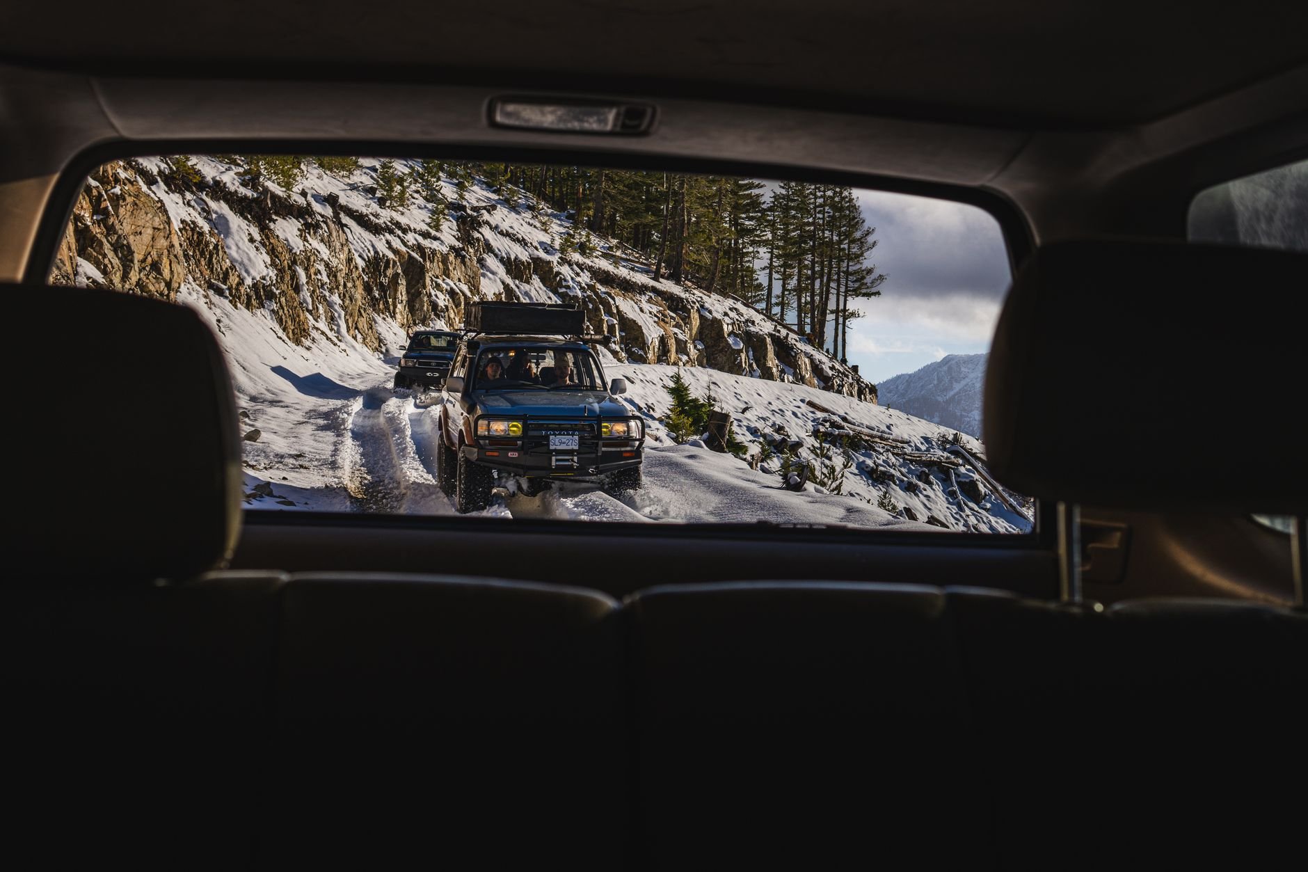 Rugged 4x4 vehicles on snowy mountain paths