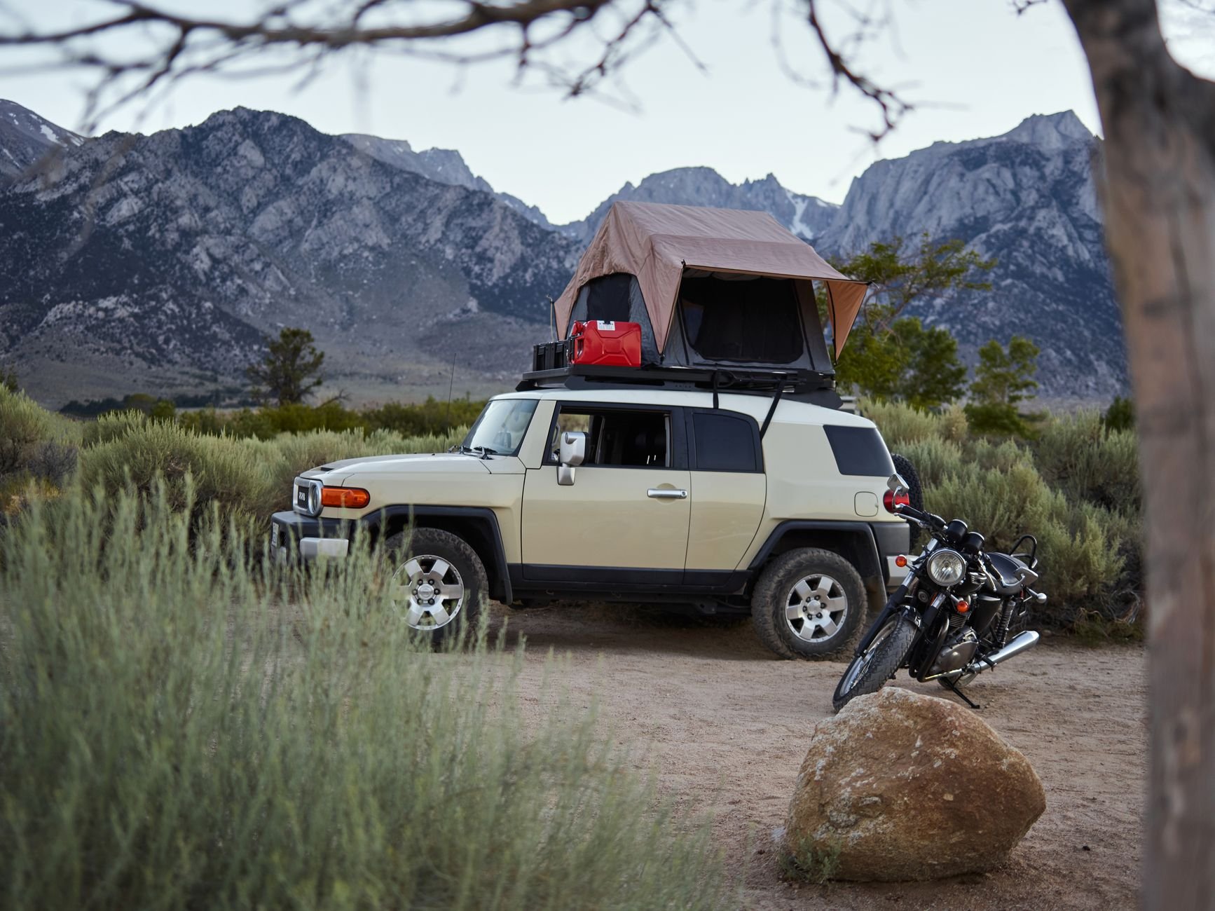 Off-road vehicle with rooftop tent in a scenic mountain landscape